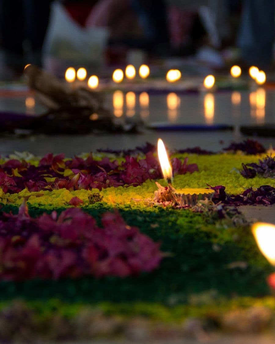 Hands cradling a lit Diwali diya